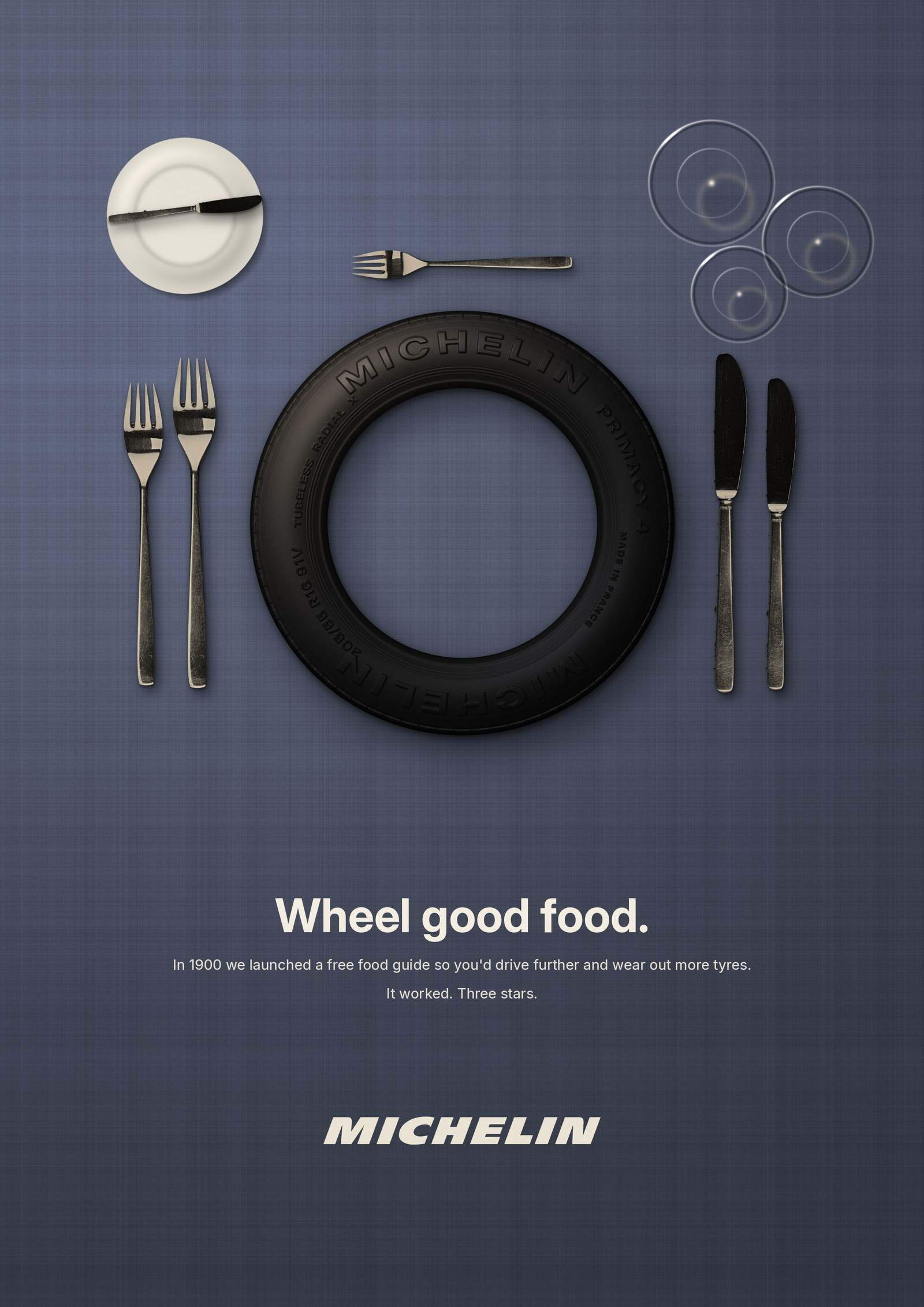 Michelin poster: a tyre laid as the plate at a fine-dining table setting, headline Wheel good food