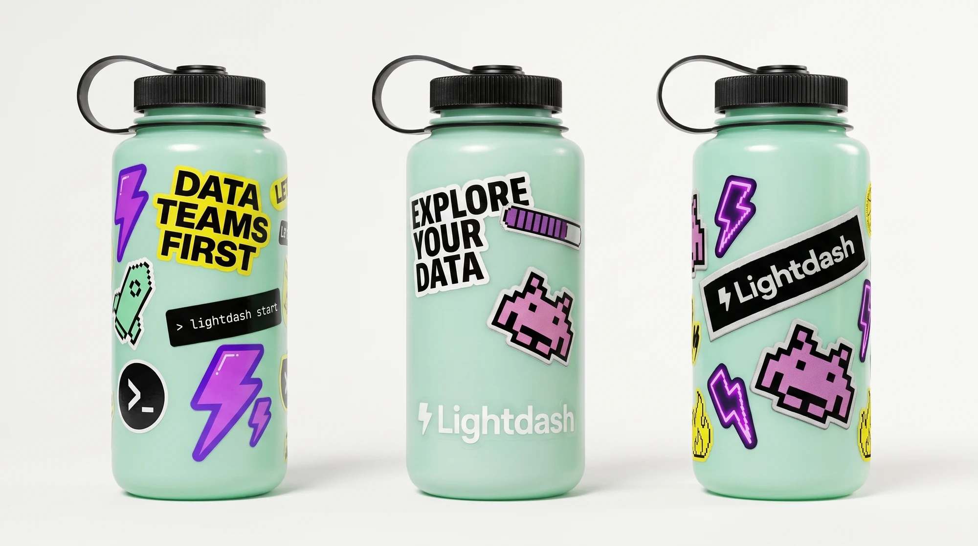 Three mint wide-mouth water bottles covered in Lightdash stickers, including Data teams first, Explore your data, pixel bolts, a space invader and the Lightdash wordmark